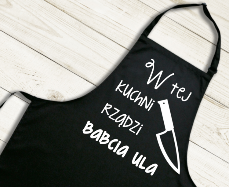 4 fartuch.png Bawełniany fartuch „W tej kuchni rządzi Babcia Ula” – personalizowany prezent PixelNadruk.pl